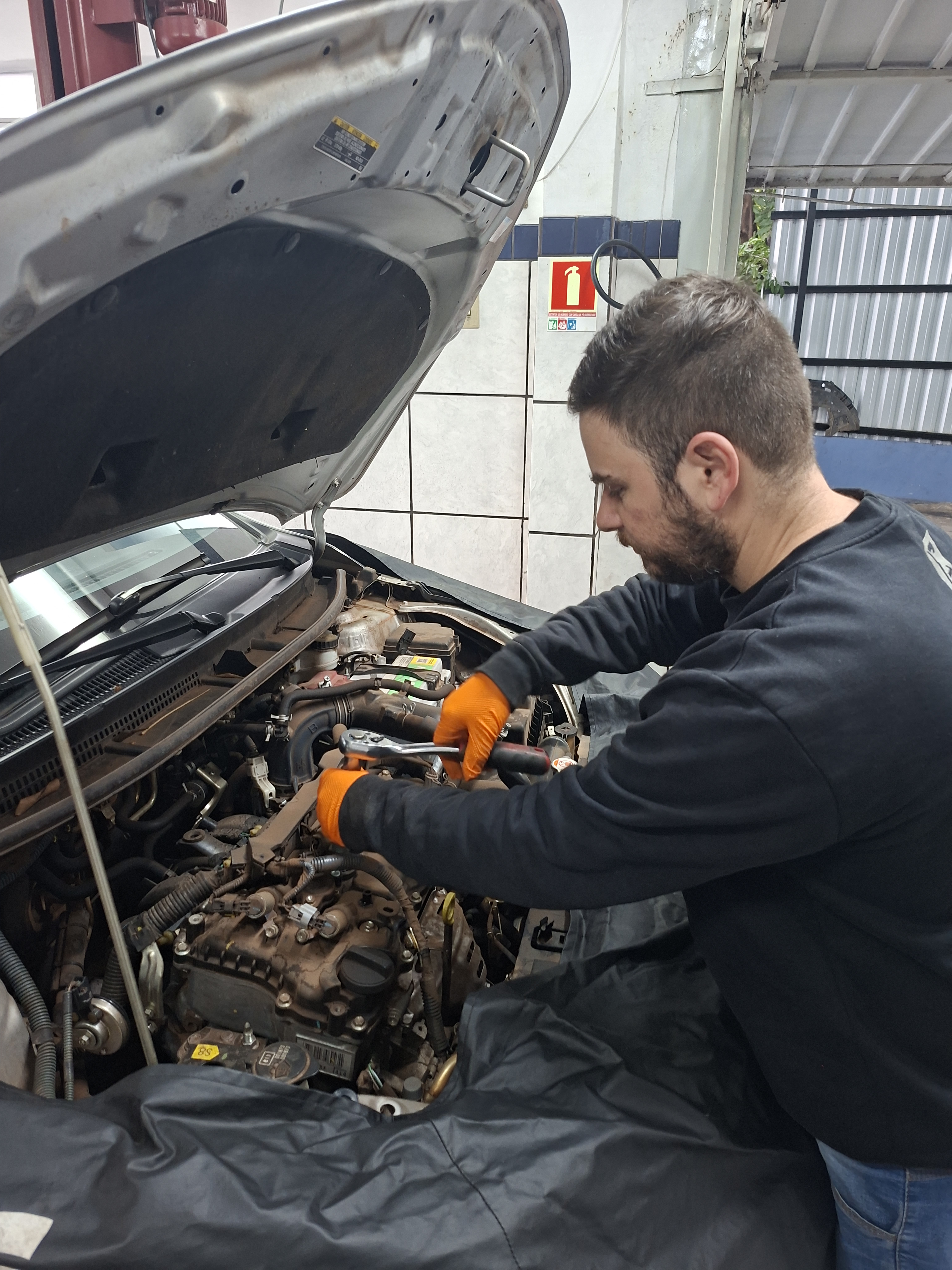 Mecânico da Epic Motors realizando manutenção no motor do veículo em Passo Fundo