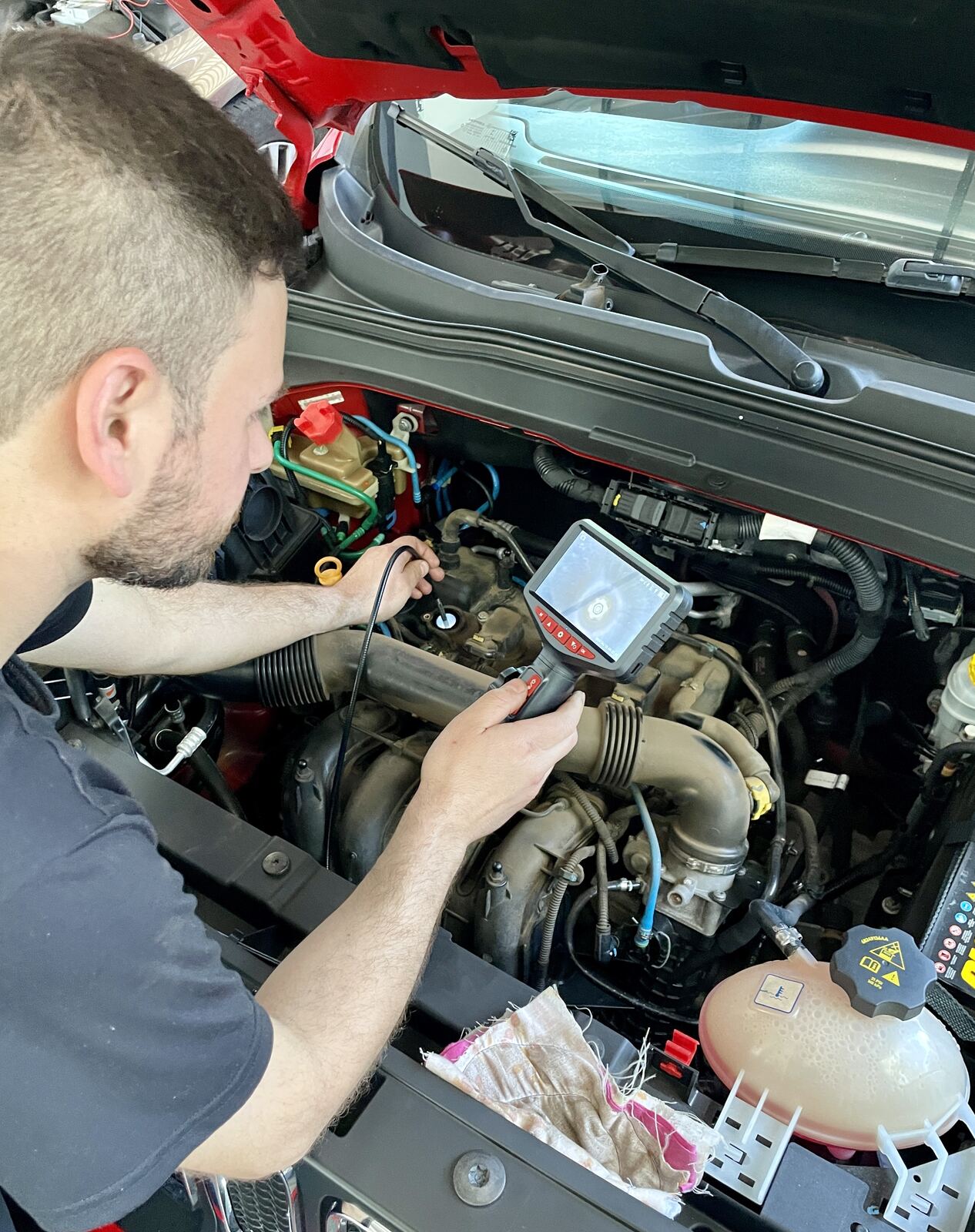Mecânico realizando diagnóstico eletrônico avançado no motor do veículo